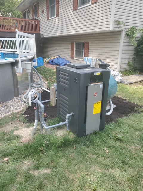 Rheem pool heater cleanly installed and plumbed next to an above-ground pool by J & L Mechanical